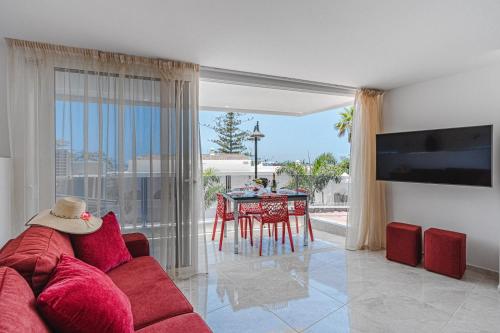 een woonkamer met een rode bank en een tafel bij Magaly in Los Cristianos