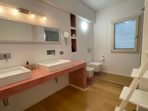 布多尼的住宿－La Pecora Nera B&B，一间带两个盥洗盆和卫生间的浴室