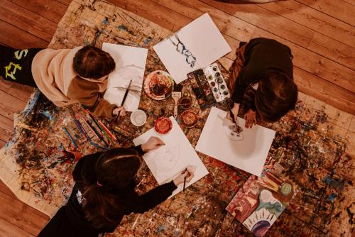 a group of people sitting at a table cutting paper at Hotel Bergschlössl in Luson