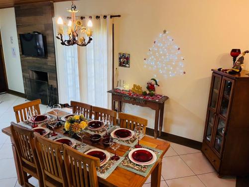 un comedor con una mesa y un árbol de Navidad en Casa para Descanso, en Campos do Jordão
