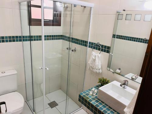 a bathroom with a glass shower and a sink at Casa para Descanso in Campos do Jordão