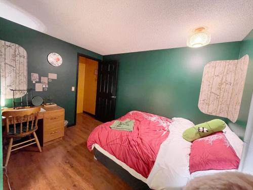 1 dormitorio con cama roja y escritorio en Lu Yao Inn OP en Calgary