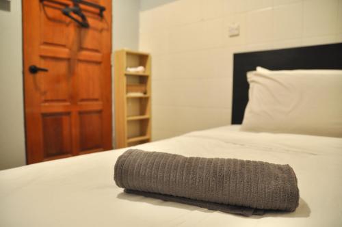 a gray blanket laying on top of a bed at GRAYHAUS Guest House in Petaling Jaya