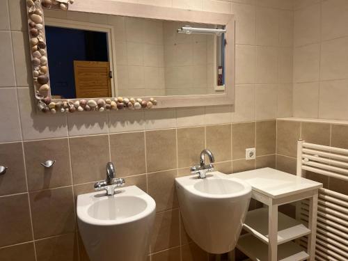 ein Badezimmer mit zwei Urinalen und einem Spiegel in der Unterkunft Cozy home with a view on the harbour in Brielle