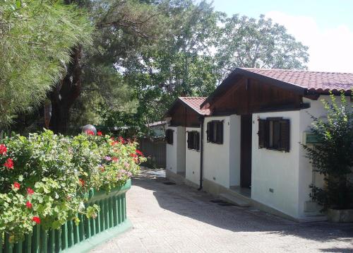 a small house with a fence and some flowers at Holiday Residence in Casamassima