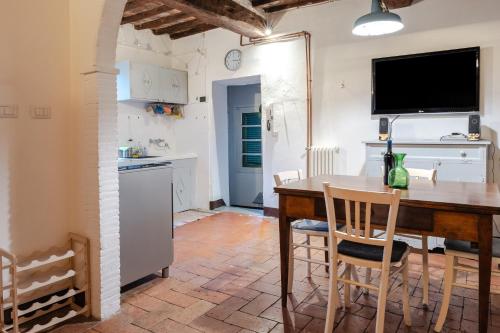 eine Küche und ein Esszimmer mit einem Tisch und Stühlen in der Unterkunft Il Convento in Sansepolcro