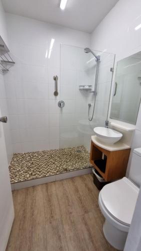 a bathroom with a shower and a toilet and a sink at Upmarket Beach Flat, Free WiFi & DisneyPlus in Durban