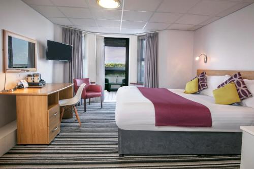 a hotel room with a bed and a desk at Best Western Lancaster Morecambe Lothersdale Hotel in Morecambe