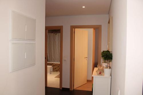 un couloir avec une porte menant à une salle de bains. dans l'établissement Appartement Pinheiro, à Portimão