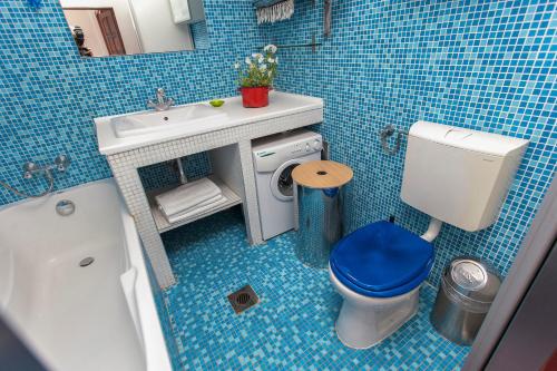ブダペストにあるApartment Egusiの青いタイル張りのバスルーム(トイレ、シンク付)