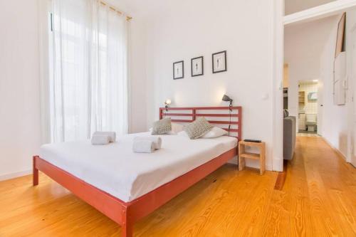 a large bed in a room with a wooden floor at São Vicente @ Heart of Alfama in Lisbon