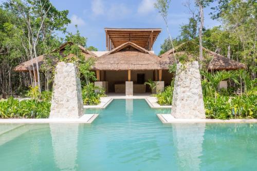uma villa com piscina e um resort em Lumina at LOSANTOS Tulum em Tulum