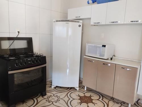 a kitchen with a refrigerator and a stove and a microwave at Recanto Hórus próximo a Capitólio e Serra da Canastra in Piauí