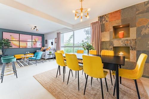 a dining room with a table and yellow chairs at NEW Cheerful Family Friendly Roma Norte Condo in Mexico City