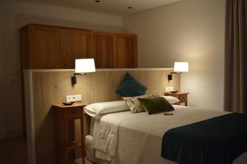 a bedroom with a bed with two lamps on it at Apartamentos Turísticos La Plaza in Chipiona