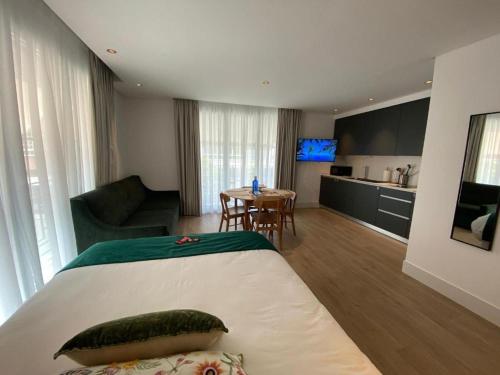 a hotel room with a bed and a living room at Apartamentos Turísticos La Plaza in Chipiona