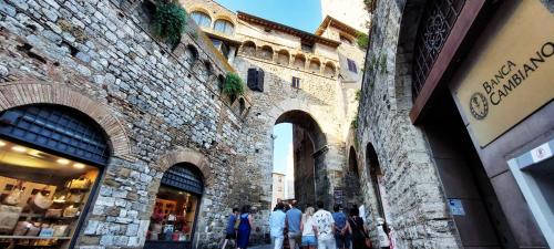 a group of people walking down a street next to a building at Casa nel centro storico in San Gimignano