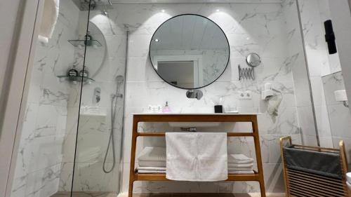a bathroom with a shower and a sink and a mirror at Apartamentos Turísticos La Plaza in Chipiona