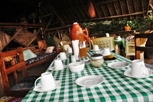 una mesa con un mantel a cuadros verde y blanco en Mikoko Beach & Cottages en Bagamoyo