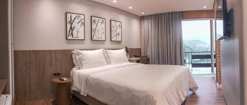 a hotel room with a bed and a window at Village Du Lac Hotel in Pomerode