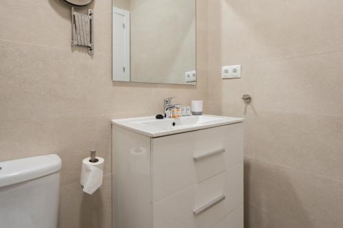 a white bathroom with a sink and a toilet at Aire del Sur Cádiz in Cádiz