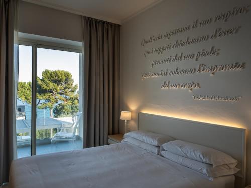 a bedroom with a bed with writing on the wall at La Chiave dei Trabocchi in San Vito Chietino