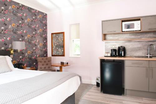 a hotel room with a bed and a kitchen at Cricklade House Hotel, Sure Hotel Collection by Best Western in Cricklade