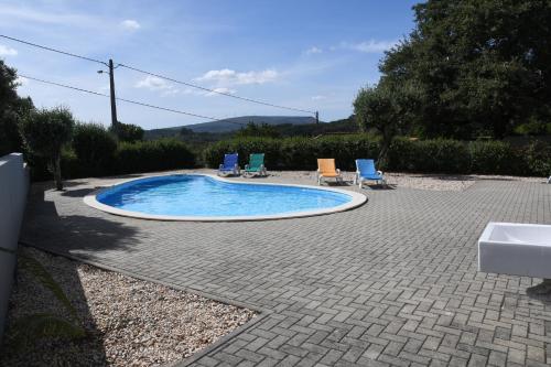 a small swimming pool with chairs and a sink at Casa de Sandoeira in Rego da Murta