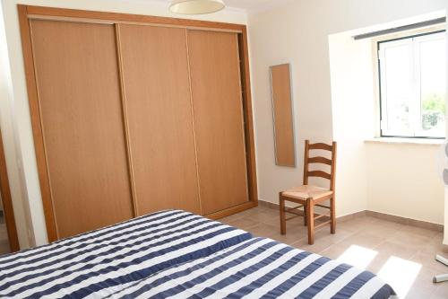 a bedroom with a bed and a wooden cabinet at Casa de Sandoeira in Rego da Murta