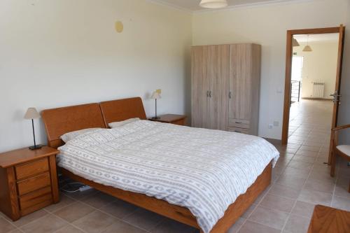 a bedroom with a bed and a wooden cabinet at Casa de Sandoeira in Rego da Murta