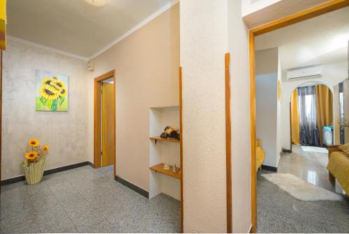 ein Wohnzimmer mit einem Sofa und einer Vase aus Blumen in der Unterkunft Holiday Apartment Ariella in Križanici