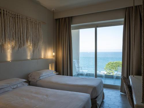 a hotel room with two beds and a view of the ocean at La Chiave dei Trabocchi in San Vito Chietino