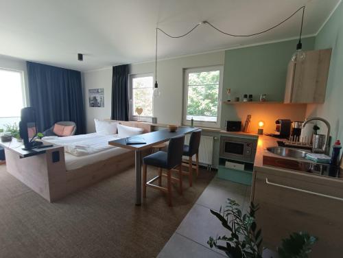 a room with a bed and a kitchen with a table at Fewo am Plöner See in Ascheberg
