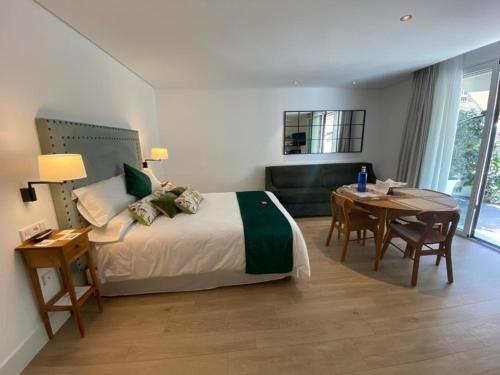 a hotel room with a bed and a table and a tableablish at Apartamentos Turísticos La Plaza in Chipiona