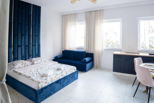 1 dormitorio con 1 cama azul y 1 silla azul en Apartament BRYZA DE LUXE z JACUZZI en Gdynia
