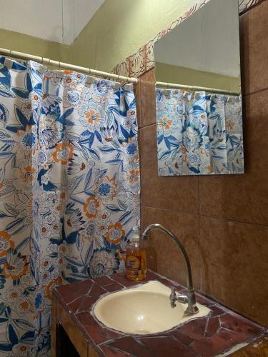 Mauras Tropical Mini Hostel & Tours في باكيرا: حمام مع حوض ومرآة