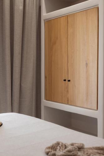 a cupboard in a bedroom with a white bed at Villa Finest -Seaside Villa with private swimming pool at Orkos in Mikri Vigla