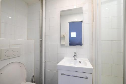 une salle de bain blanche avec des toilettes et un lavabo dans l'établissement Cléry 57, à Paris
