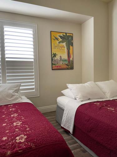 a bedroom with two beds and a picture on the wall at Private Los Angeles Room - Free WIFI, AC, TV, Private Fridge, Kitchen, near USC - Exposition Park - USC Memorial Coliseum - Banc of California BMO Stadium - Downtown Los Angeles DTLA - University of Southern California USC!!! in Los Angeles