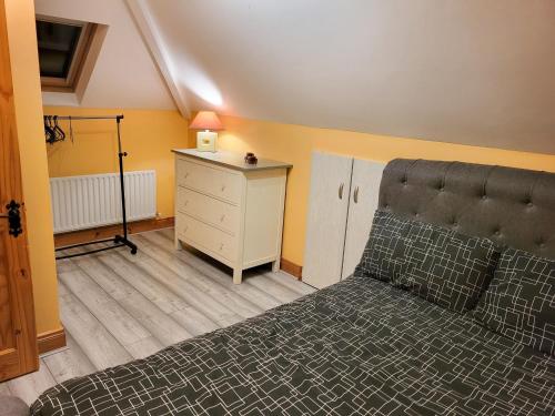 um quarto com uma cama e uma cómoda com um candeeiro em Ballygarrett Holiday Home em Ballygarrett