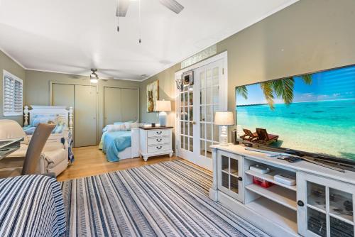 a bedroom with a bed and a large screen tv at Siesta Key Oasis with Outdoor Pool and Screened Lanai! in Siesta Key