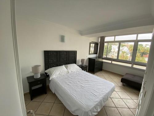 a bedroom with a white bed and a window at Eurosol in Torremolinos
