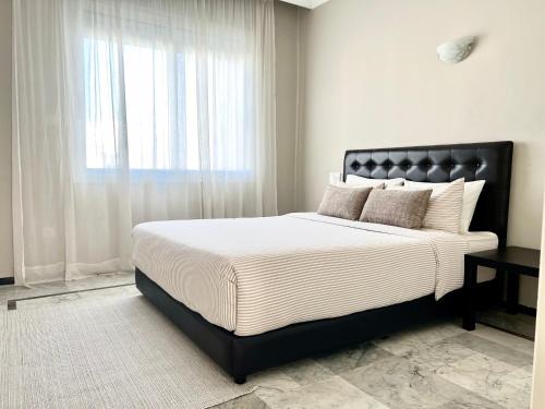 a bedroom with a large bed with a window at Appartement face à la mer et à 10min du centre-ville in Casablanca