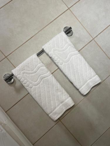 a pair of towels on the floor of a bathroom at Airport Apartments Alexandra in Surčin