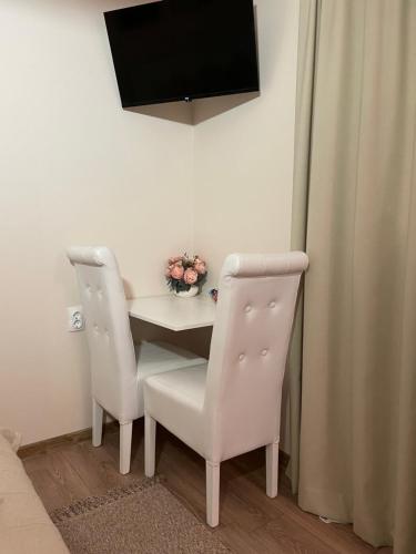a small table with two chairs and a television at Airport Apartments Alexandra in Surčin