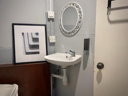 a bathroom with a sink and a mirror on the wall at GRAYHAUS Guest House in Petaling Jaya