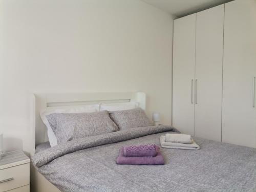 a bedroom with a large bed with purple blankets and pillows at MDM Apartman Vrnjačka Banja in Vrnjačka Banja