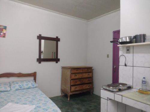 a bedroom with a bed and a dresser and a mirror at Residencial Ravasco in Camamu