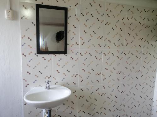 a bathroom with a sink and a mirror at Casa lowcost relajación total! in La Dorada