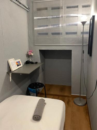 a room with a bed and a table and a window at GRAYHAUS Guest House in Petaling Jaya
